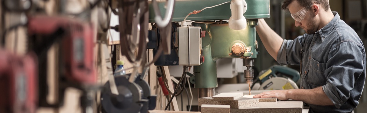 Tischler mit einer Bohrmaschine